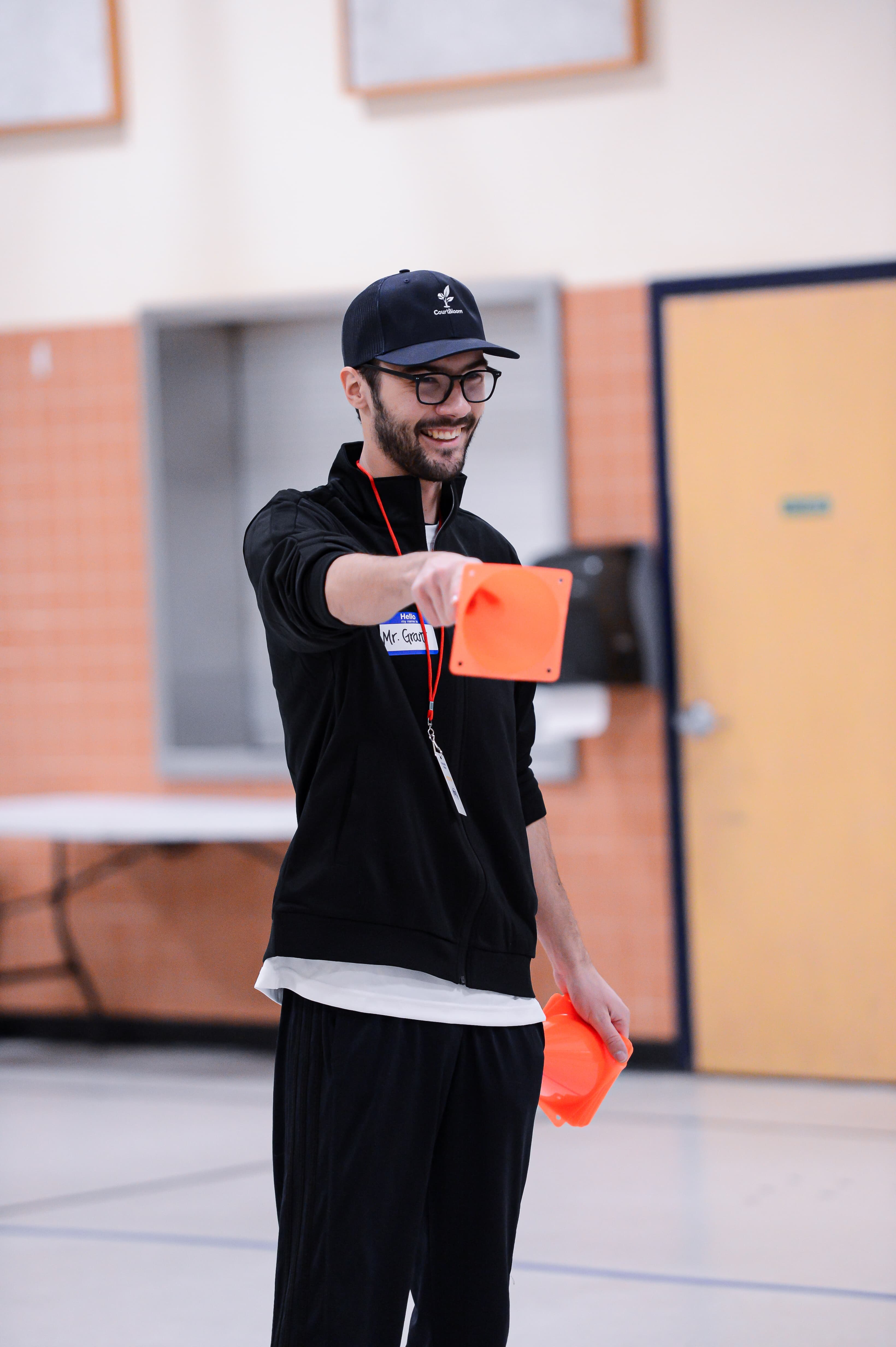 CourtBloom youth tennis photo — coach cone trap